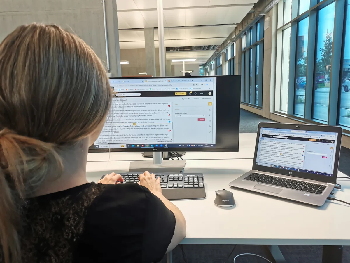 Ein Foto über die Schulter auf den Computerbildschirm. Jemand schreibt gerade an einem Artikel.